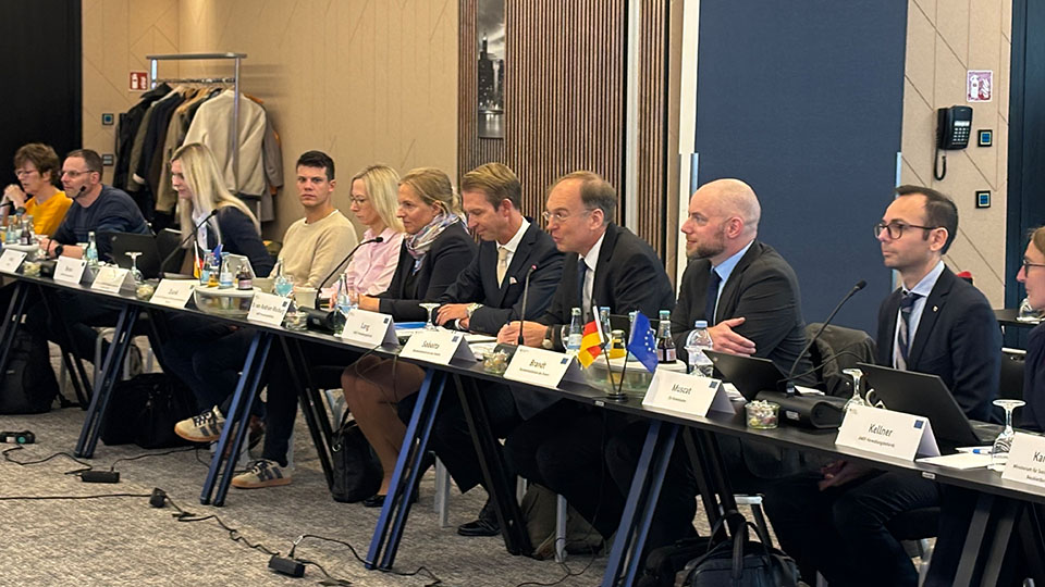 Mehrere Frauen und Männer sitzen an Tischen. Vor ihnen liegen Namenschilder. (Quelle: Bundesamt für Migration und Flüchtlinge) Mehrere Frauen und Männer sitzen an Tischen. Vor ihnen liegen Namenschilder.