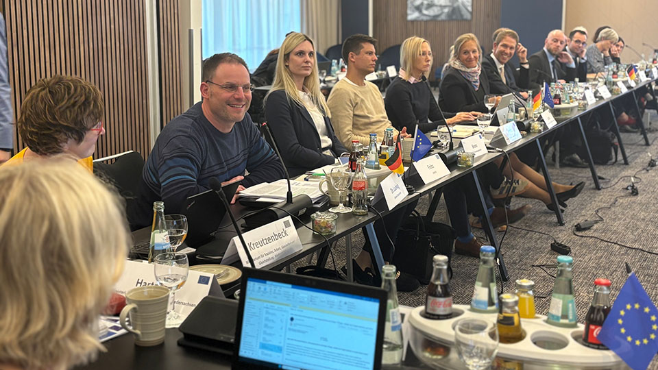 Mehrere Frauen und Männer sitzen an Tischen. Vor ihnen liegen Namenschilder. (Quelle: Bundesamt für Migration und Flüchtlinge) Mehrere Frauen und Männer sitzen an Tischen. Vor ihnen liegen Namenschilder.