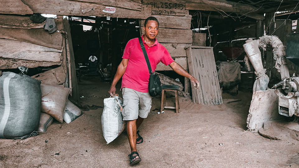 Ein Mann trägt eine Tüte von seiner Farm weg. (Quelle: Social Impact gGmbH) Ein Mann trägt eine Tüte von seiner Farm weg.