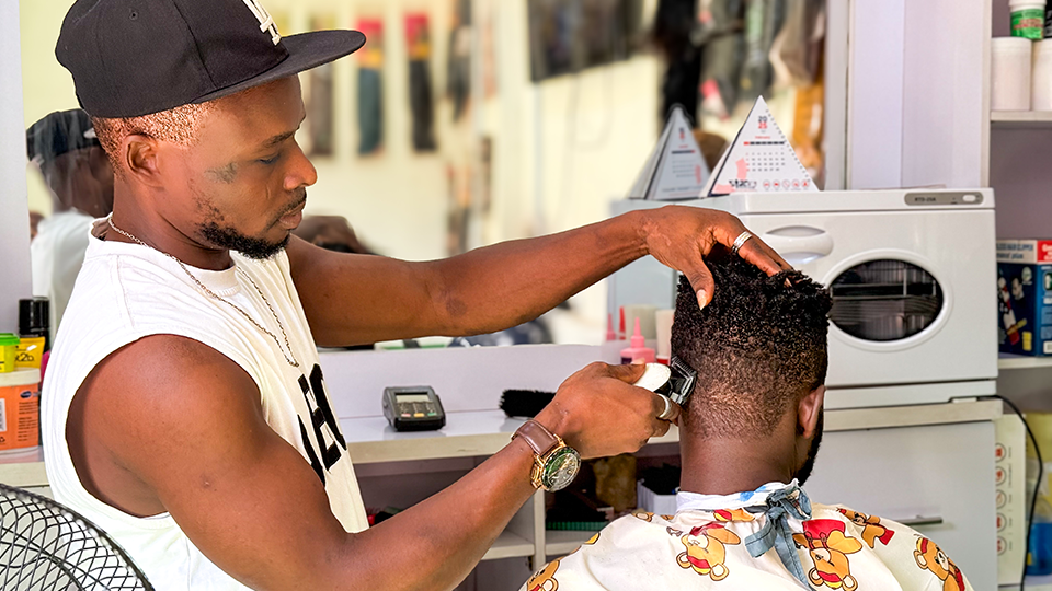 Ein Mann schneidet einem anderen Mann in einem Barbershop die Haare. (Quelle: Social Impact gGmbH) Ein Mann schneidet einem anderen Mann in einem Barbershop die Haare.