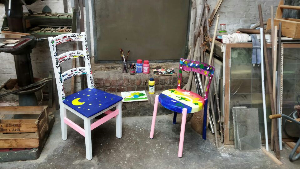 Zwei von Teilnehmenden bemalte Stühle stehen in einem Atelier. (Quelle: Diözesan-Caritasverband für das Erzbistum Köln e. V.) Zwei von Teilnehmenden bemalte Stühle stehen in einem Atelier.