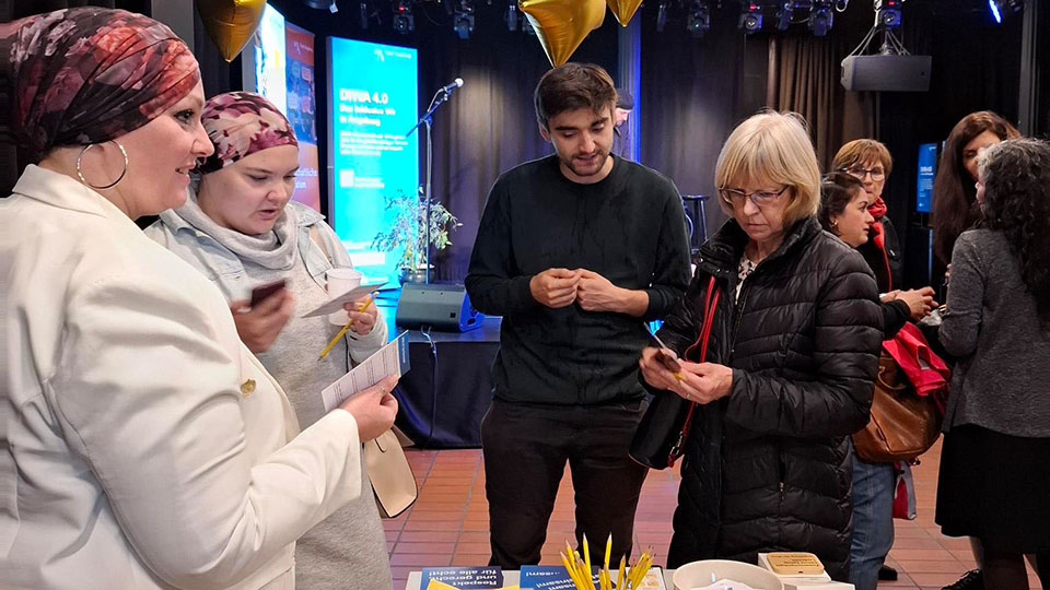 Drei Frauen und ein Mann stehen neben einem gedeckten Tisch. (Quelle: Stadt Augsburg) Drei Frauen und ein Mann stehen neben einem gedeckten Tisch.